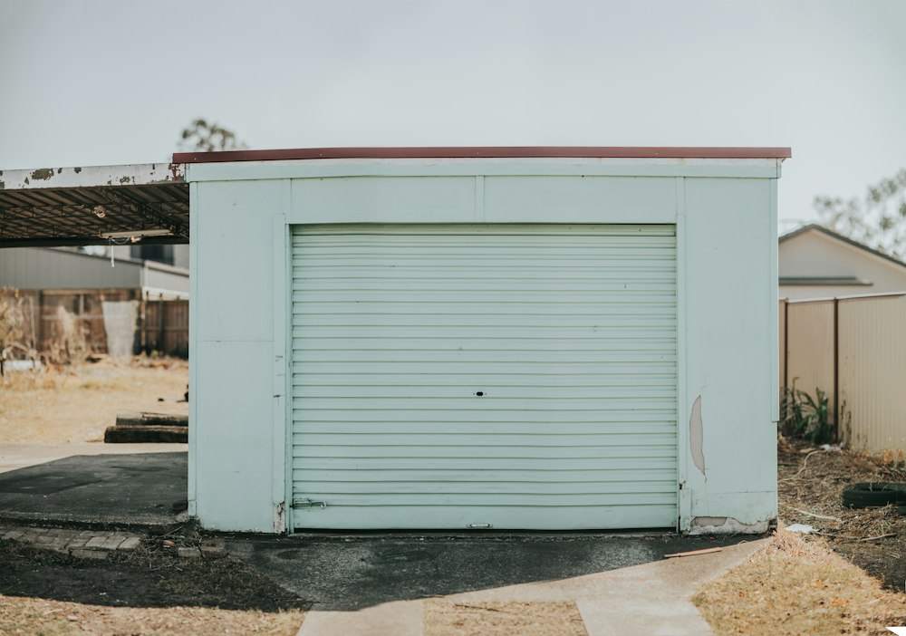 Garage avec une porte enroulable à lames blanches