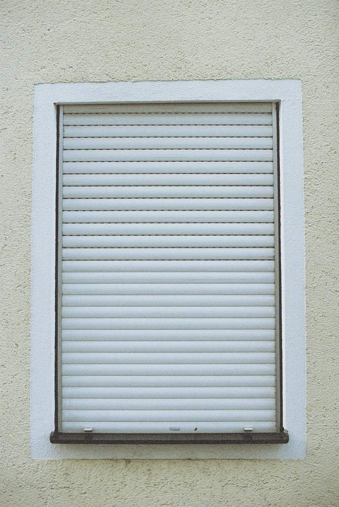 Fenêtre avec un volet roulant blanc fermé