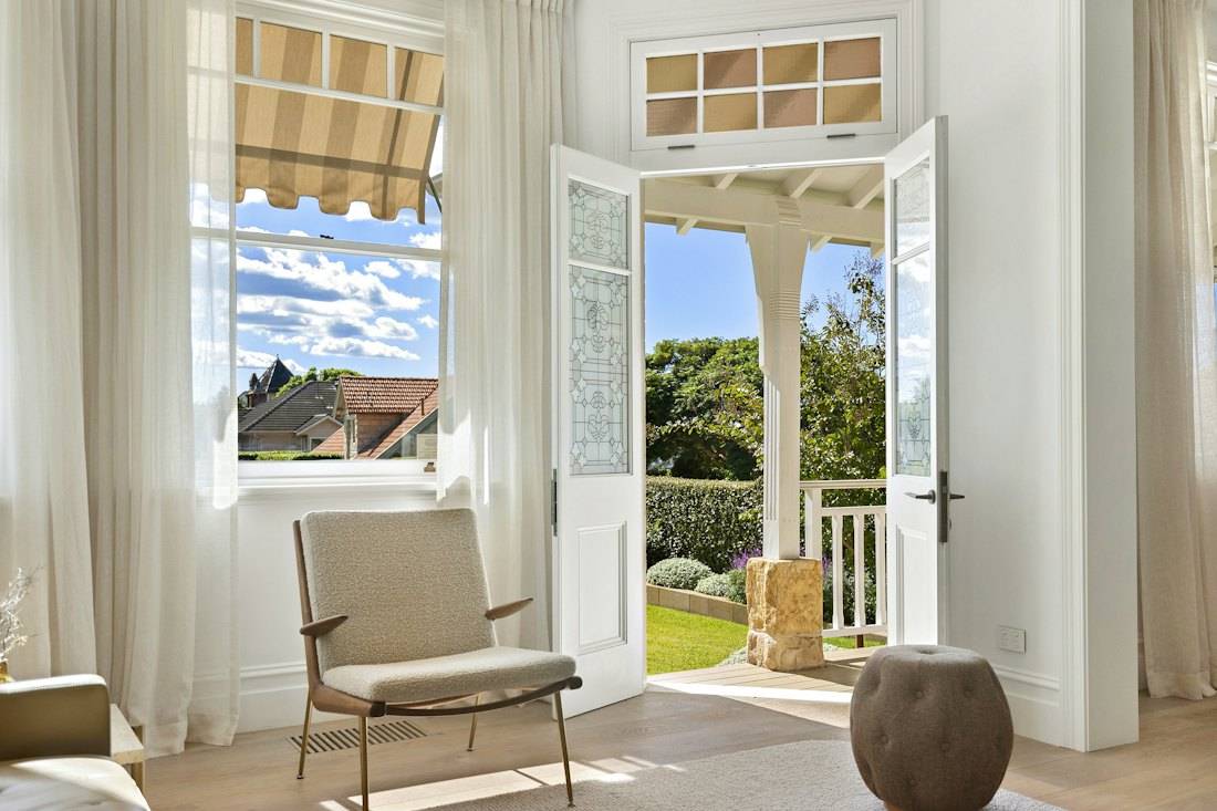 Porte-fenêtre ouverte sur un jardin depuis un salon lumineux
