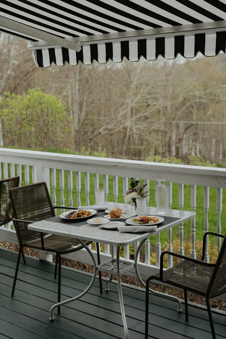 Store banne rayé au-dessus d’une table de terrasse