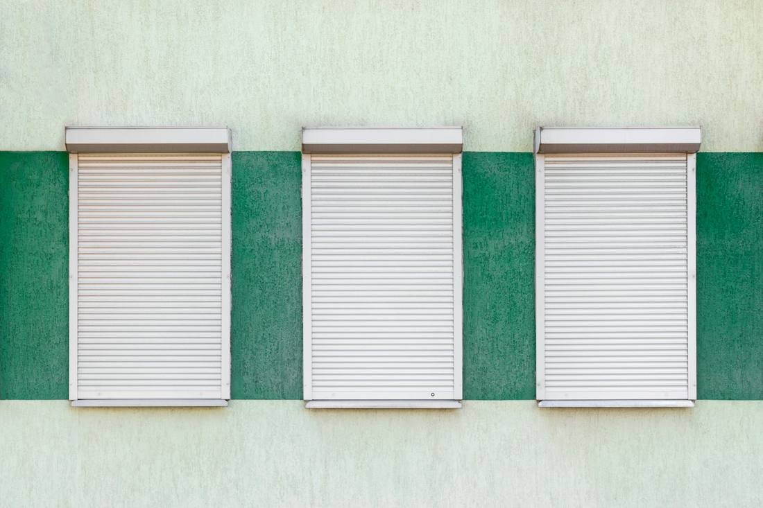 Volets roulants blancs sur une façade ensoleillée
